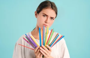 Paille en plastique : les nouvelles alternatives pour les restaurants une fille qui porte dans ses mains des pailles en plastique