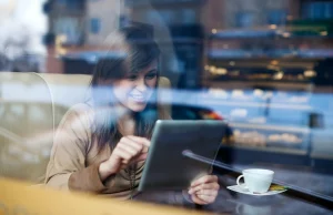 Quels sont les avantages de l’utilisation des tables tactiles dans votre restaurant ? une femme dans un restaurant en train de commander via une table tactile