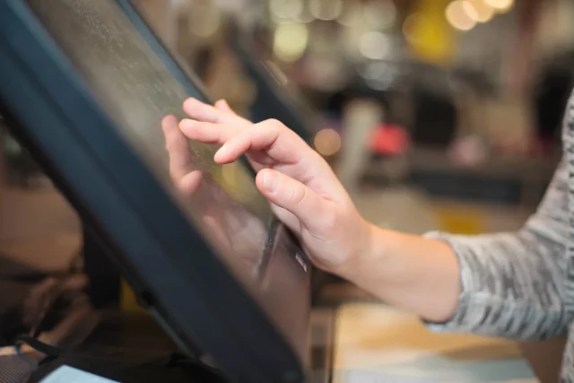 une femme en train d'utiliser le logiciel de caisse d'un restaurant