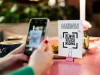 QR code de menu restaurant : pour un menu sans contact une femme scanne le qr code d'un menu dans un restaurant par le caméra d'un smartphone