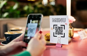 QR code de menu restaurant : pour un menu sans contact une femme scanne le qr code d'un menu dans un restaurant par le caméra d'un smartphone